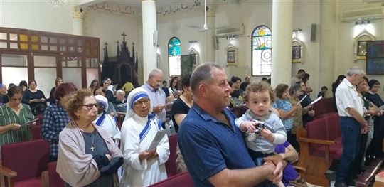 Křesťané modlící se v kostele Svaté rodiny v Gaze během konfliktu