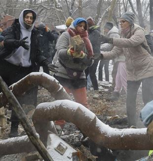 Kyjev, 3. ledna 2024. Dobrovolníci odstraňují trosky po bombardování (Foto: ANSA)